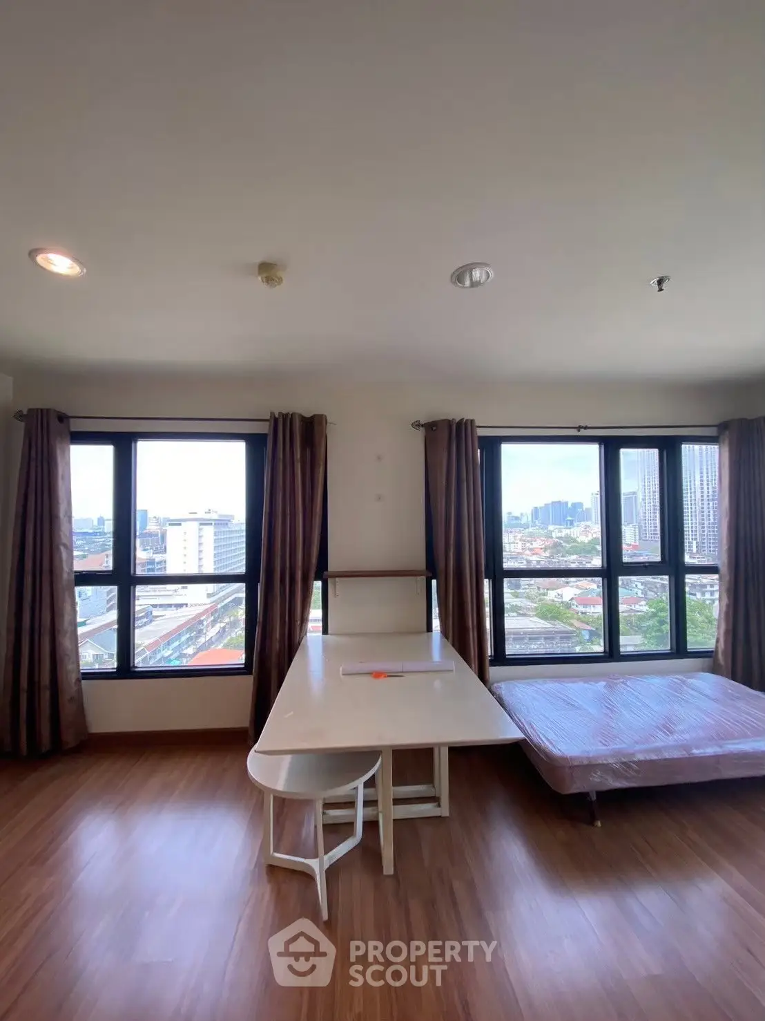 Spacious corner unit with stunning city views, featuring large windows and modern furnishings.