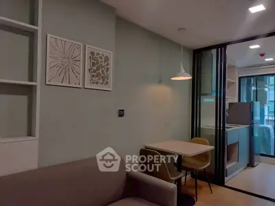 Modern living room with cozy seating and dining area, featuring stylish decor and natural lighting.