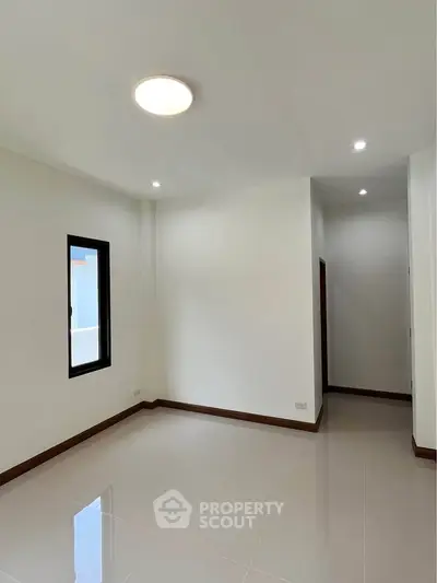 Spacious and bright empty room with glossy tiled floors and modern lighting, perfect for customization.