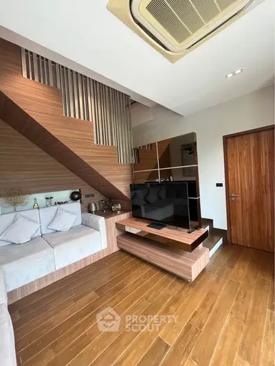 Modern living room with wooden flooring and stylish staircase design