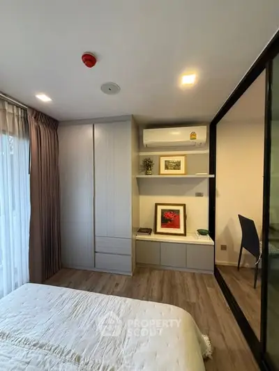 Modern bedroom with built-in wardrobe and air conditioning, featuring elegant decor and natural light.