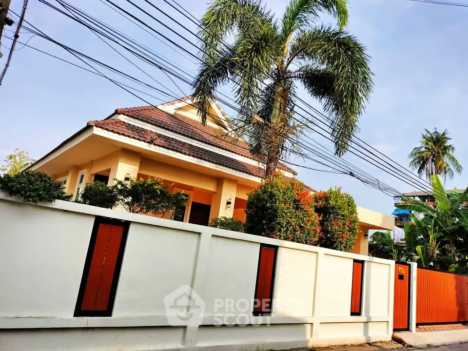 Charming suburban house with lush garden and palm trees, perfect for family living.
