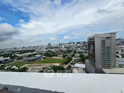 Stunning cityscape view from a high-rise building showcasing urban skyline and expansive sky.