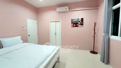 Cozy bedroom with pink walls, modern air conditioning, and stylish decor.
