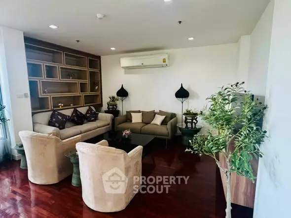 Spacious living room with elegant furniture and modern decor, featuring a cozy seating area and stylish shelving.