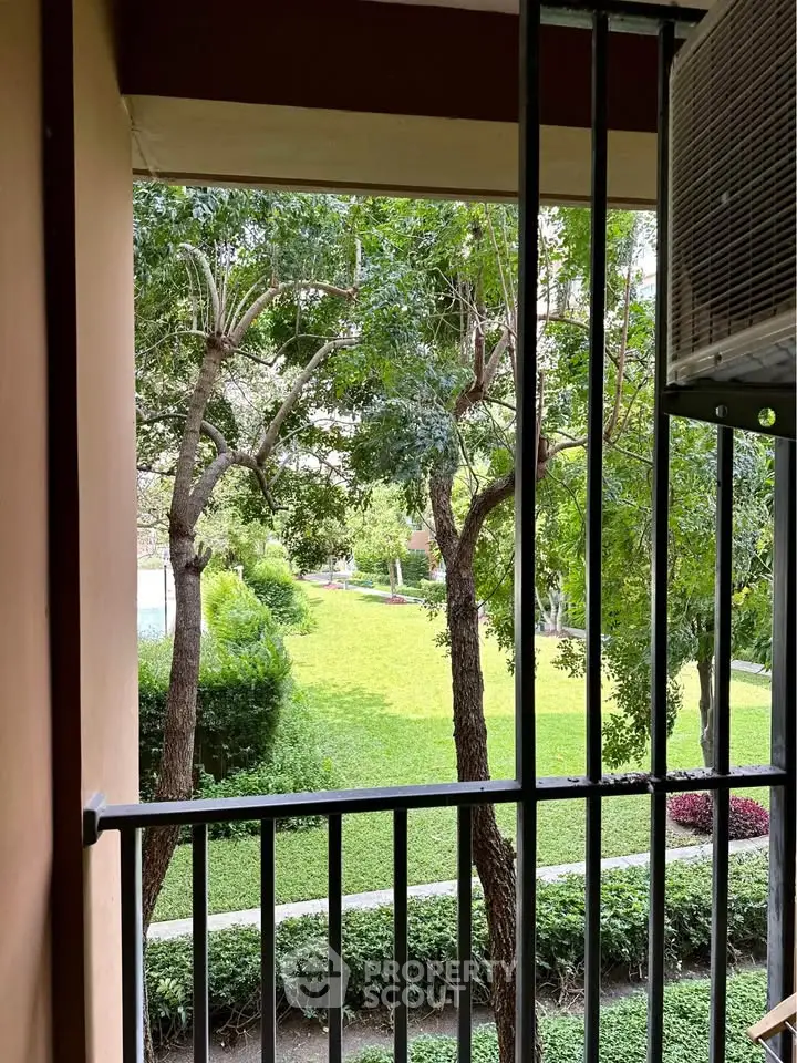 Charming garden view from a cozy balcony, perfect for relaxation.
