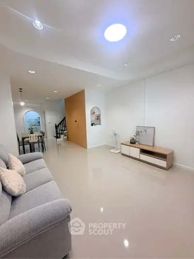 Spacious modern living room with sleek design and cozy ambiance, perfect for relaxation and entertainment.