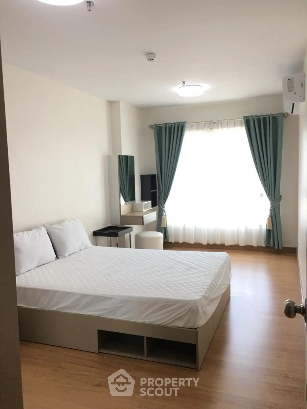 Spacious bedroom with modern decor and natural light in a stylish apartment.
