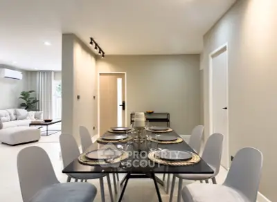 Modern dining area with elegant table setting and spacious living room view.