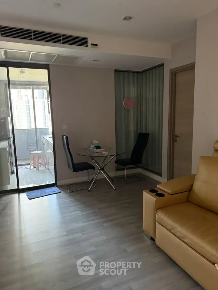 Modern living room with stylish furniture and balcony access in a contemporary apartment.