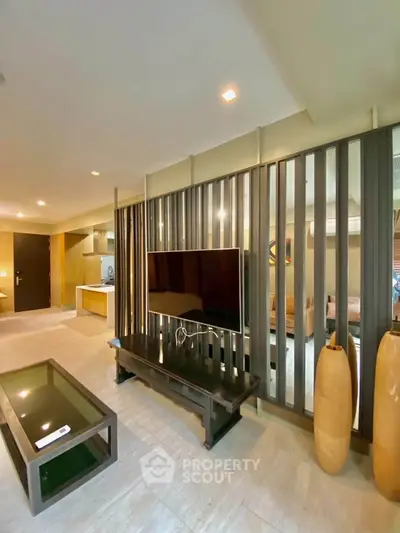 Modern living room with sleek design and open layout, featuring a stylish TV setup and elegant decor.