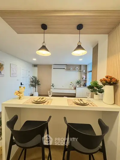 Modern open-plan living room with stylish decor and breakfast bar seating.