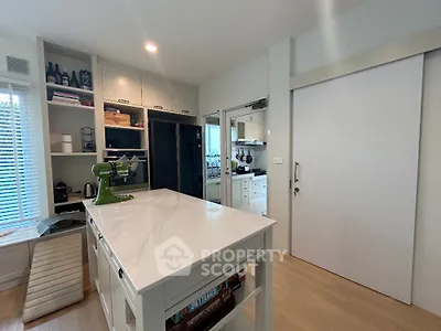 Modern kitchen with white marble island, sleek cabinetry, and high-end appliances, perfect for culinary enthusiasts.