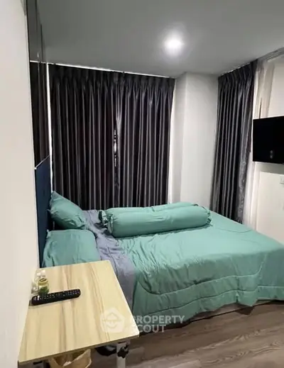 Cozy bedroom with modern decor and natural light, featuring a comfortable bed and sleek furnishings.