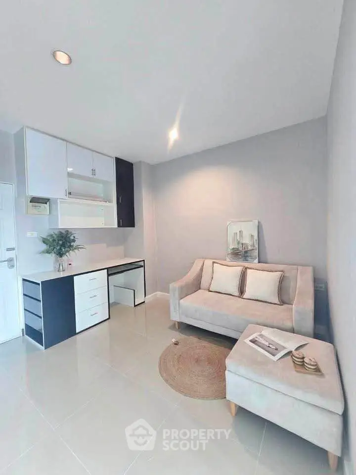 Modern living room with stylish sofa and compact kitchen in open layout apartment.