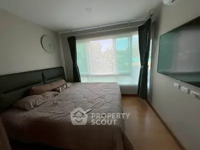 Cozy bedroom with large window and modern decor in a stylish apartment.