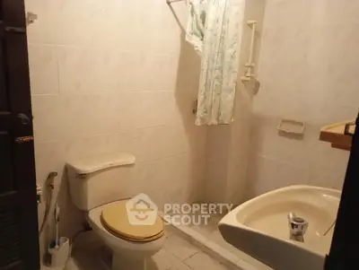 Cozy bathroom with essential fixtures and tiled walls in a real estate property.