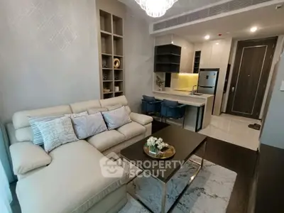 Modern living room with open kitchen, stylish decor, and cozy seating area in a contemporary apartment.
