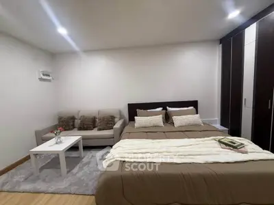 Spacious bedroom with cozy seating area and modern decor
