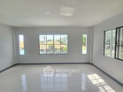 Spacious sunlit room with large windows and tiled flooring, perfect for customization.