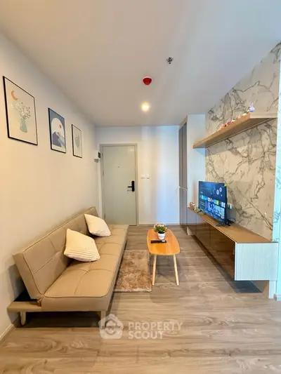 Modern living room with stylish decor and wall-mounted TV in a cozy apartment.