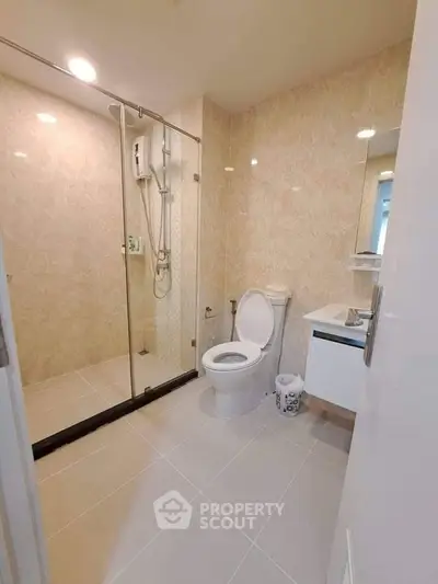 Modern bathroom with glass shower and sleek fixtures in a contemporary apartment.