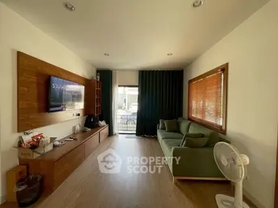 Modern living room with stylish wooden accents and cozy green sofa