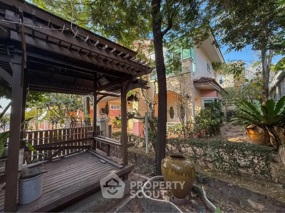 Charming garden view with rustic gazebo and lush greenery in a serene residential setting.