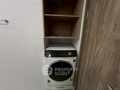 Modern laundry area with built-in shelving and Hitachi washing machine.