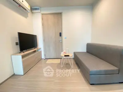 Modern living room with sleek furniture and minimalist design, featuring a comfortable sofa and flat-screen TV.