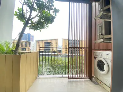 Chic urban balcony with washing machine and lush greenery view