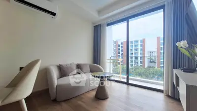 Modern living room with large window and balcony view in a stylish apartment.