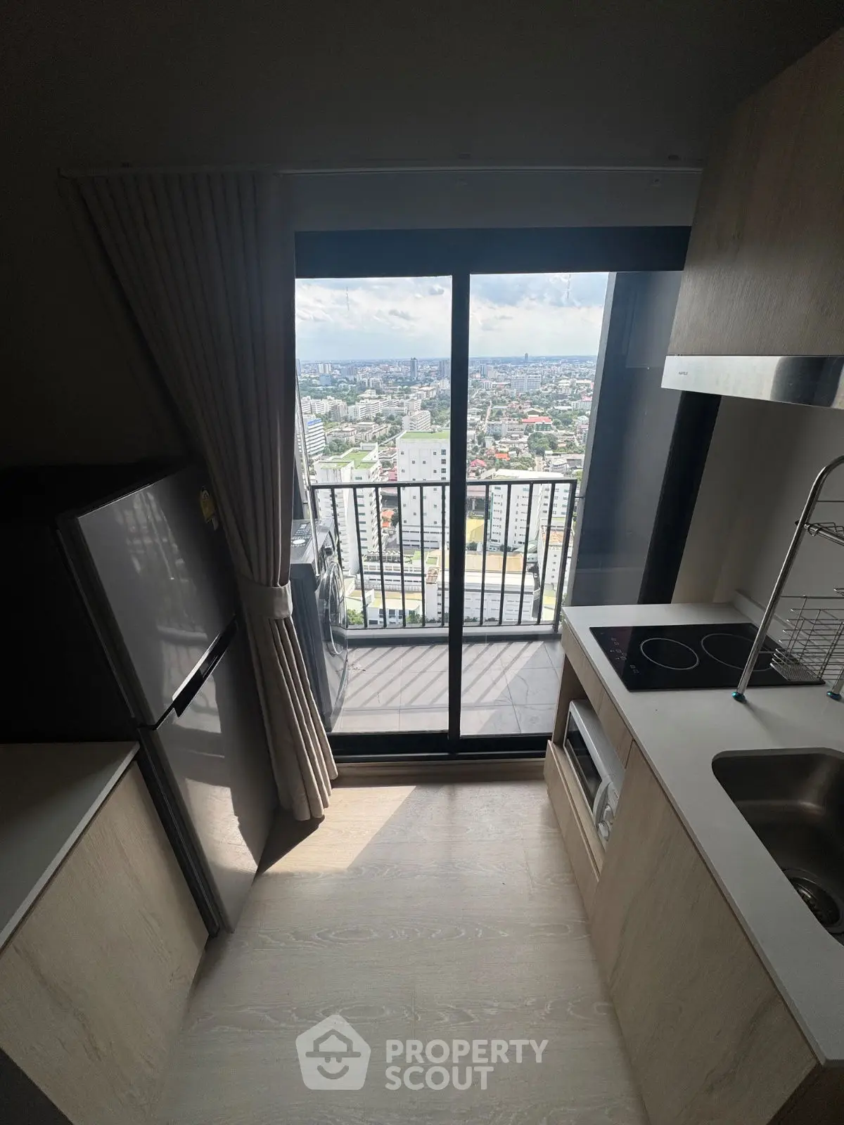 Modern kitchen with balcony view in high-rise apartment