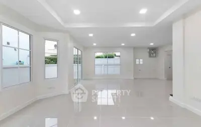 Spacious modern living room with large windows and glossy tiled floor