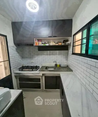 Modern kitchen with sleek cabinets and gas stove in a compact layout