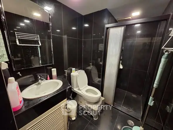Modern black-tiled bathroom with shower and sleek fixtures
