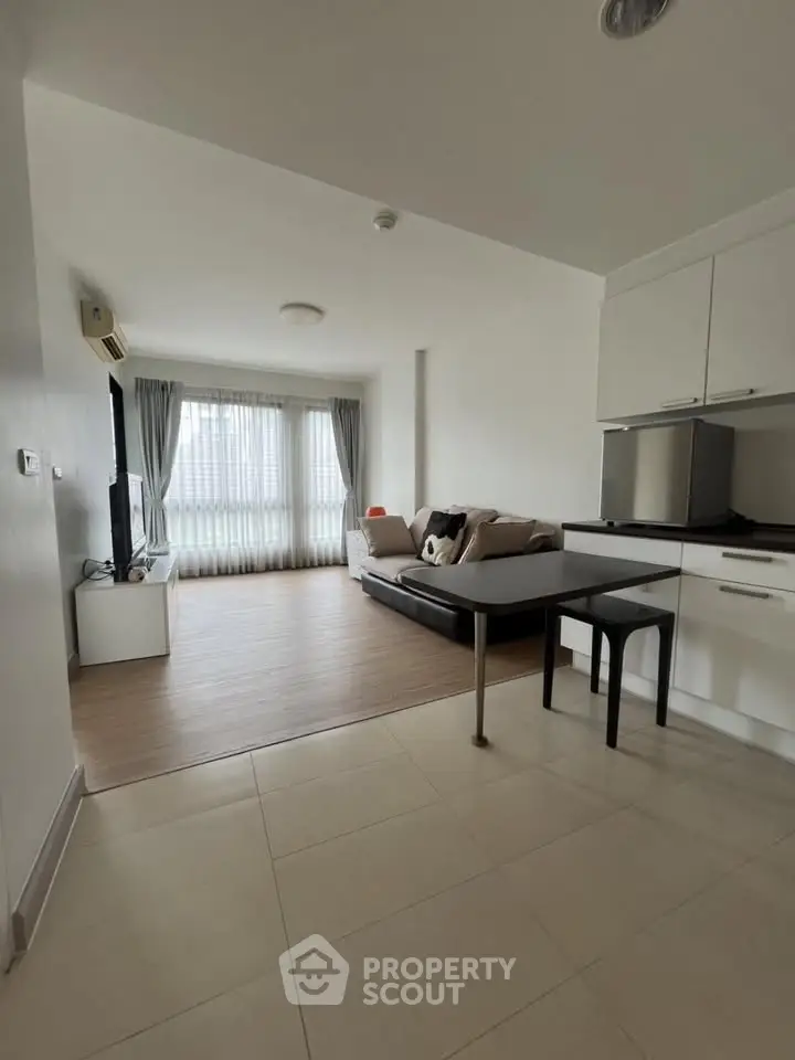 Spacious open-plan living room with modern kitchen in a bright apartment.