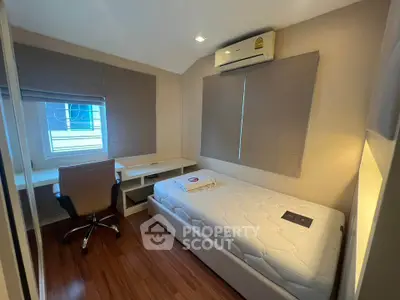 Cozy bedroom with single bed, desk, and air conditioning, perfect for a comfortable living space.