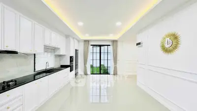 Spacious modern kitchen with sleek white cabinetry and large window view.