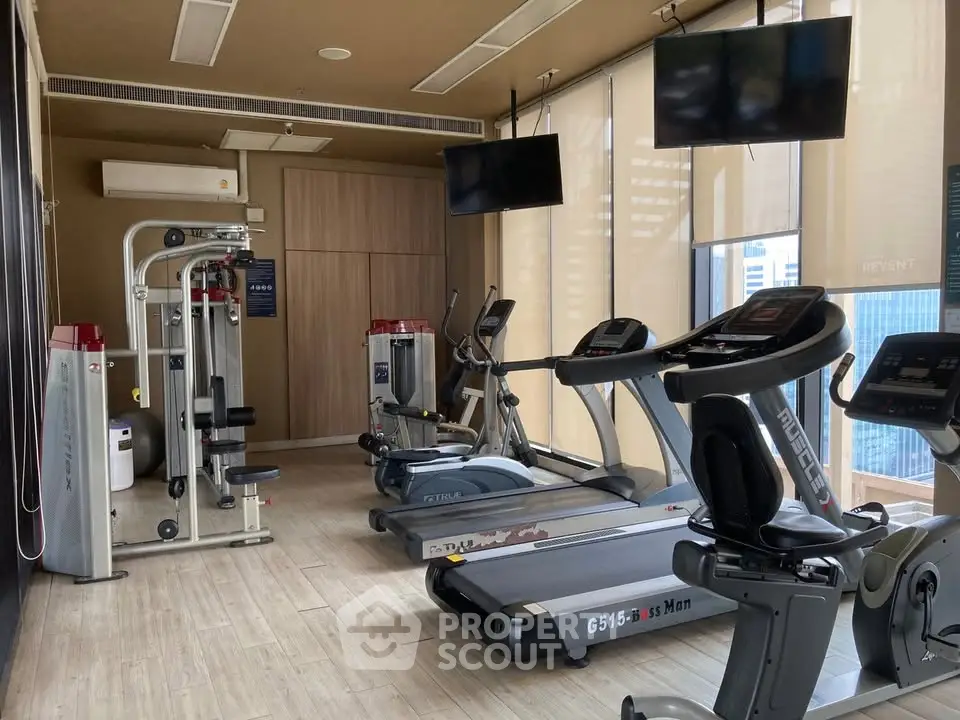 Modern gym with state-of-the-art equipment and city view, perfect for fitness enthusiasts.