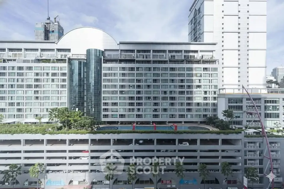 Modern high-rise building with rooftop pool and city view
