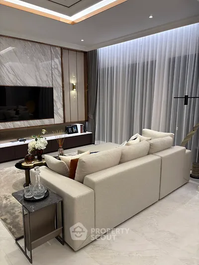 Luxurious modern living room with elegant decor and large TV, perfect for relaxation and entertainment.
