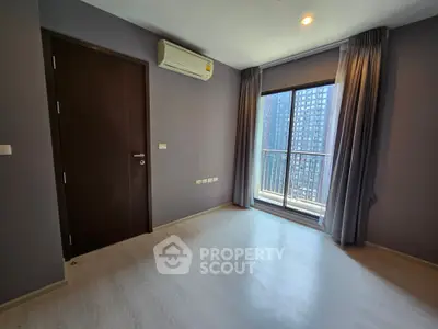 Modern bedroom with large window and city view, featuring sleek flooring and air conditioning.