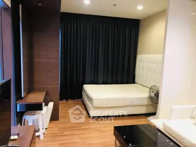 Modern studio apartment with cozy bed and sleek wooden flooring