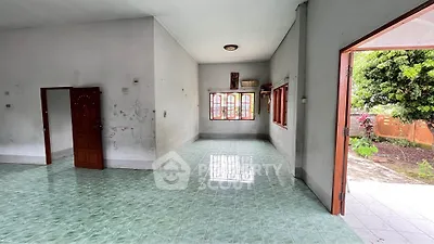 Spacious open-plan living area with tiled flooring and garden view, perfect for family gatherings.