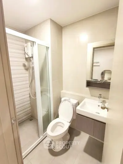 Modern bathroom with shower, toilet, and sink in a compact layout.