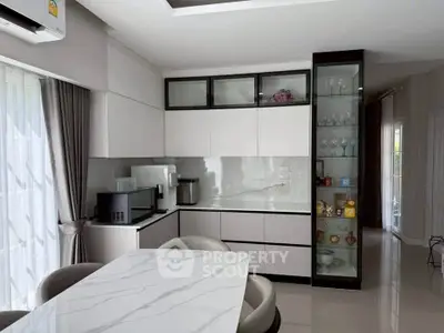 Modern kitchen with sleek cabinetry and marble dining table