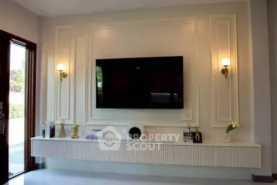 Elegant living room with modern TV setup and stylish wall sconces