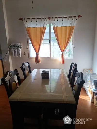 Cozy dining area with elegant curtains and wooden furniture, perfect for family gatherings.