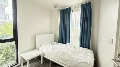 Cozy bedroom with large windows and blue curtains, perfect for natural light lovers.